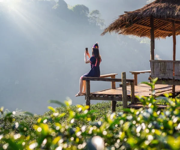 woman-wearing-hill-tribe-dress-sitting-hut-green-tea-field_335224-765